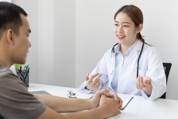 A female doctor talking to a male patient