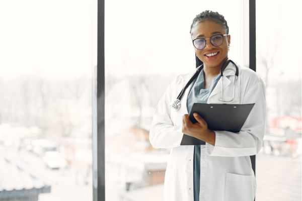 A female doctor smiling while holding a clipboard